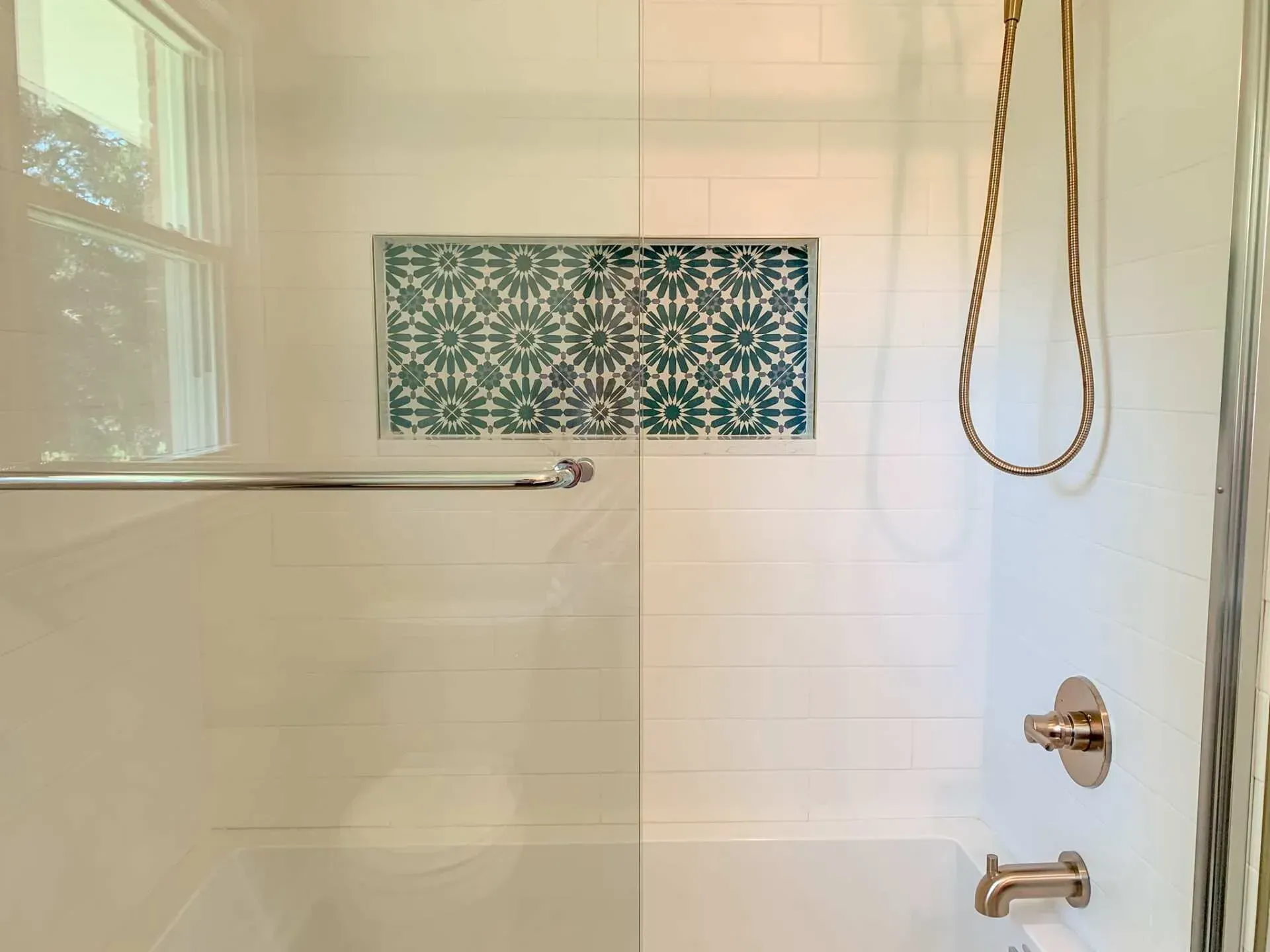 A bathroom with a shower , tub , and window.