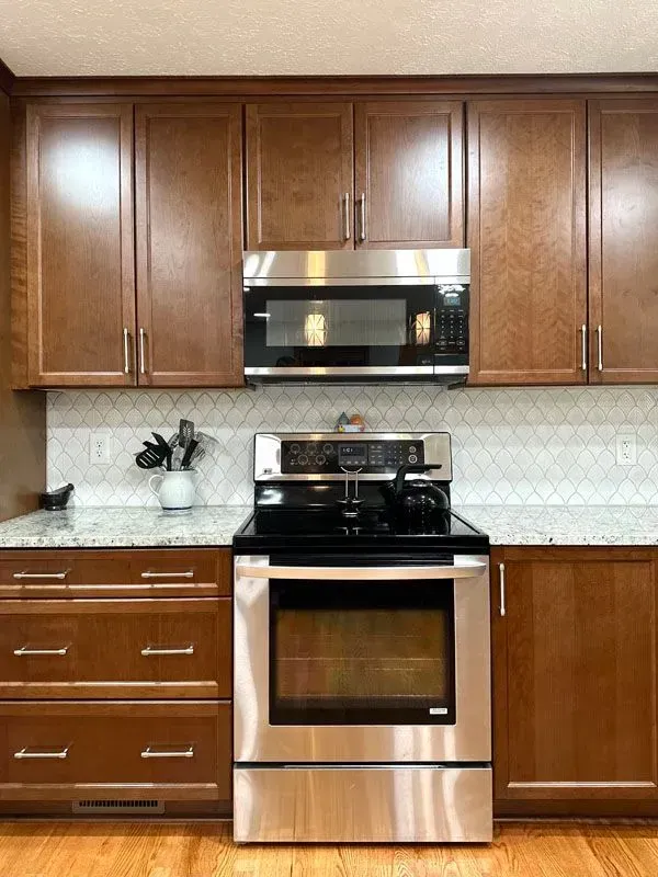 A kitchen with stainless steel appliances and wooden cabinets.