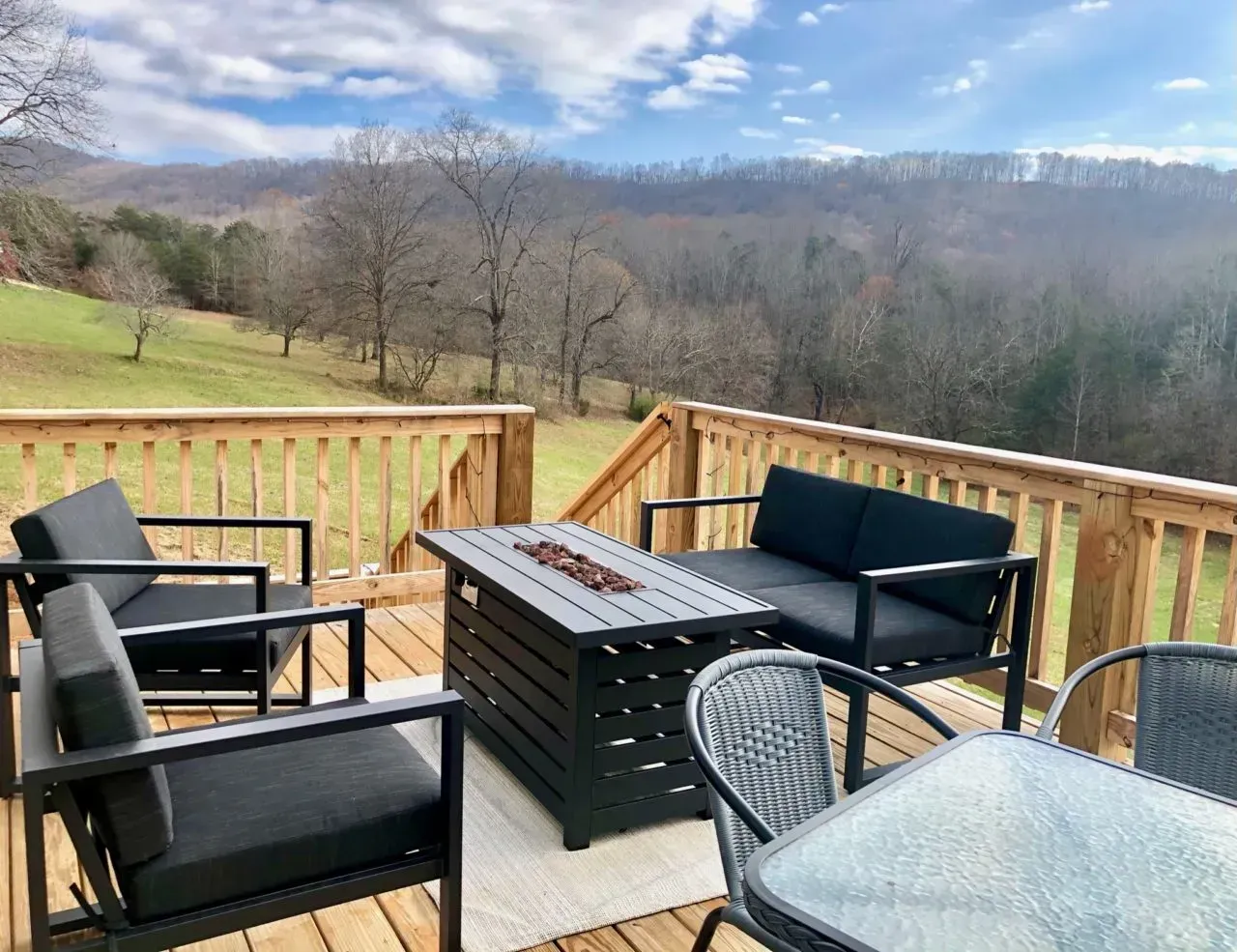 There is a fire pit on the deck with a view of the mountains.