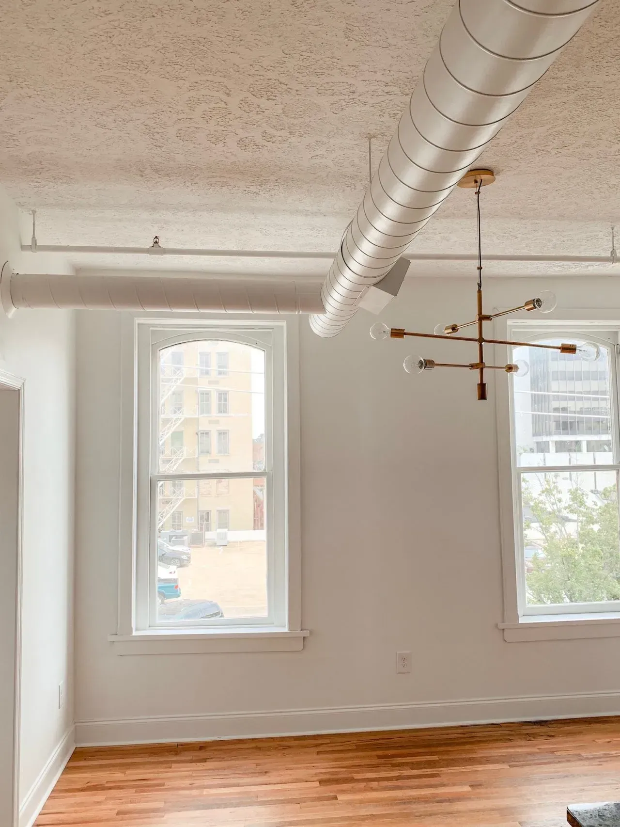An empty room with a chandelier hanging from the ceiling