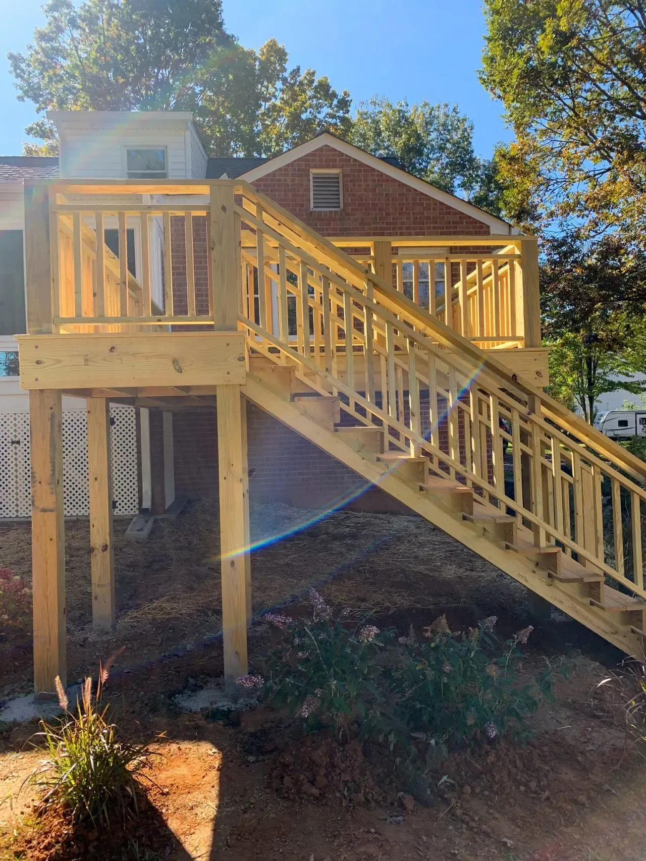 A wooden deck with stairs leading up to a house.