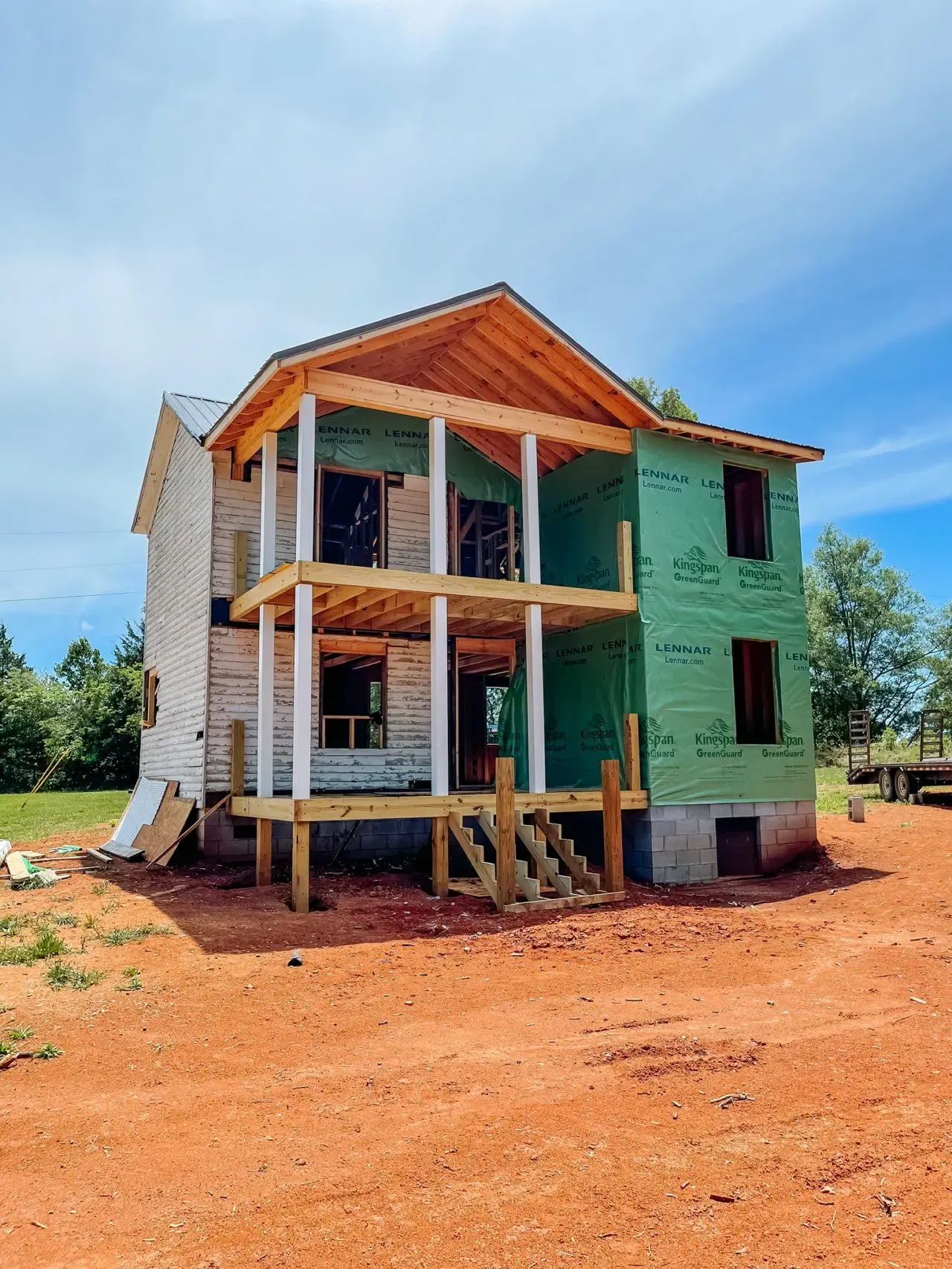 A house is being built in the middle of a dirt field.