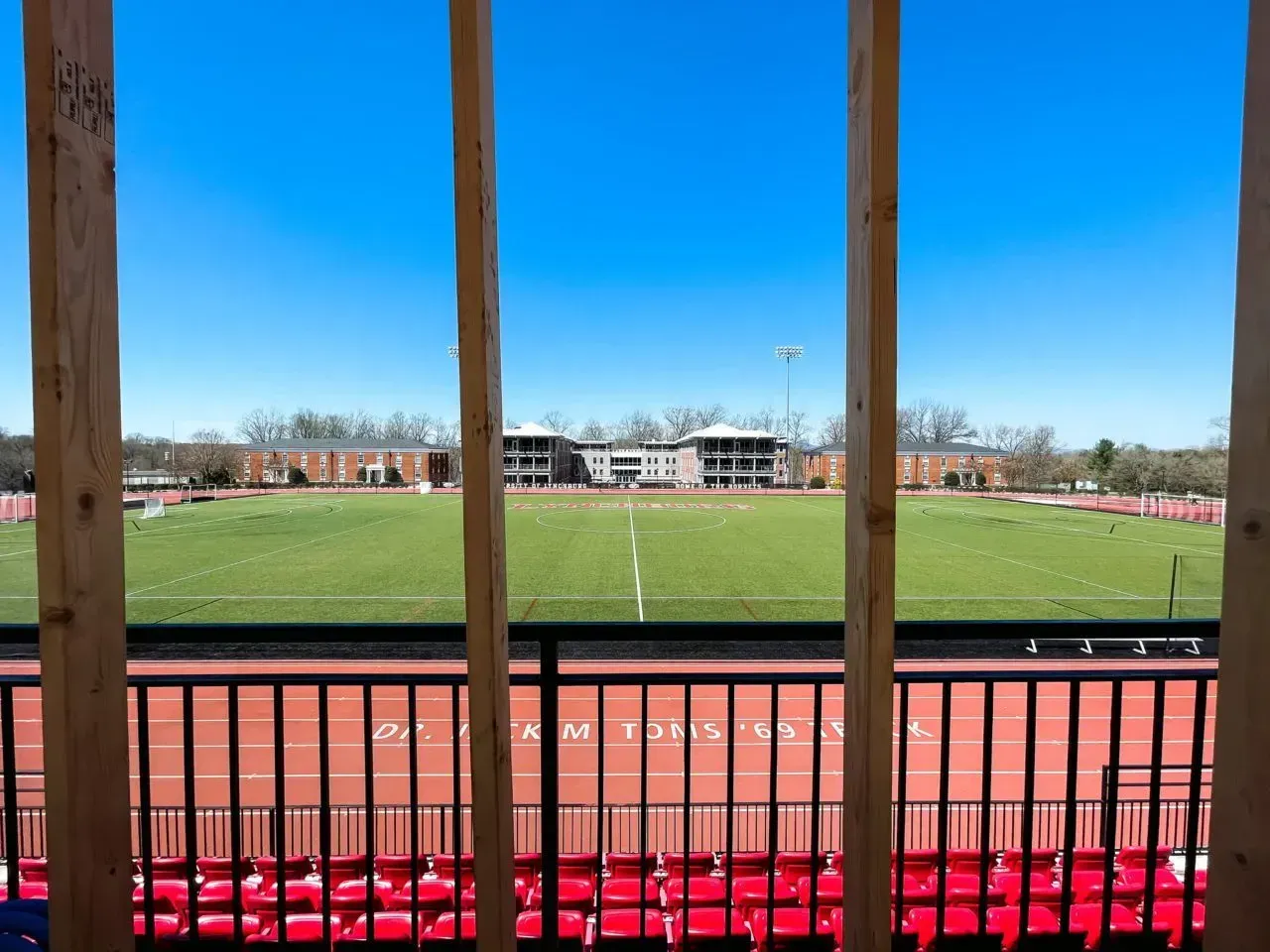 A view of a stadium from a balcony with red seats.
