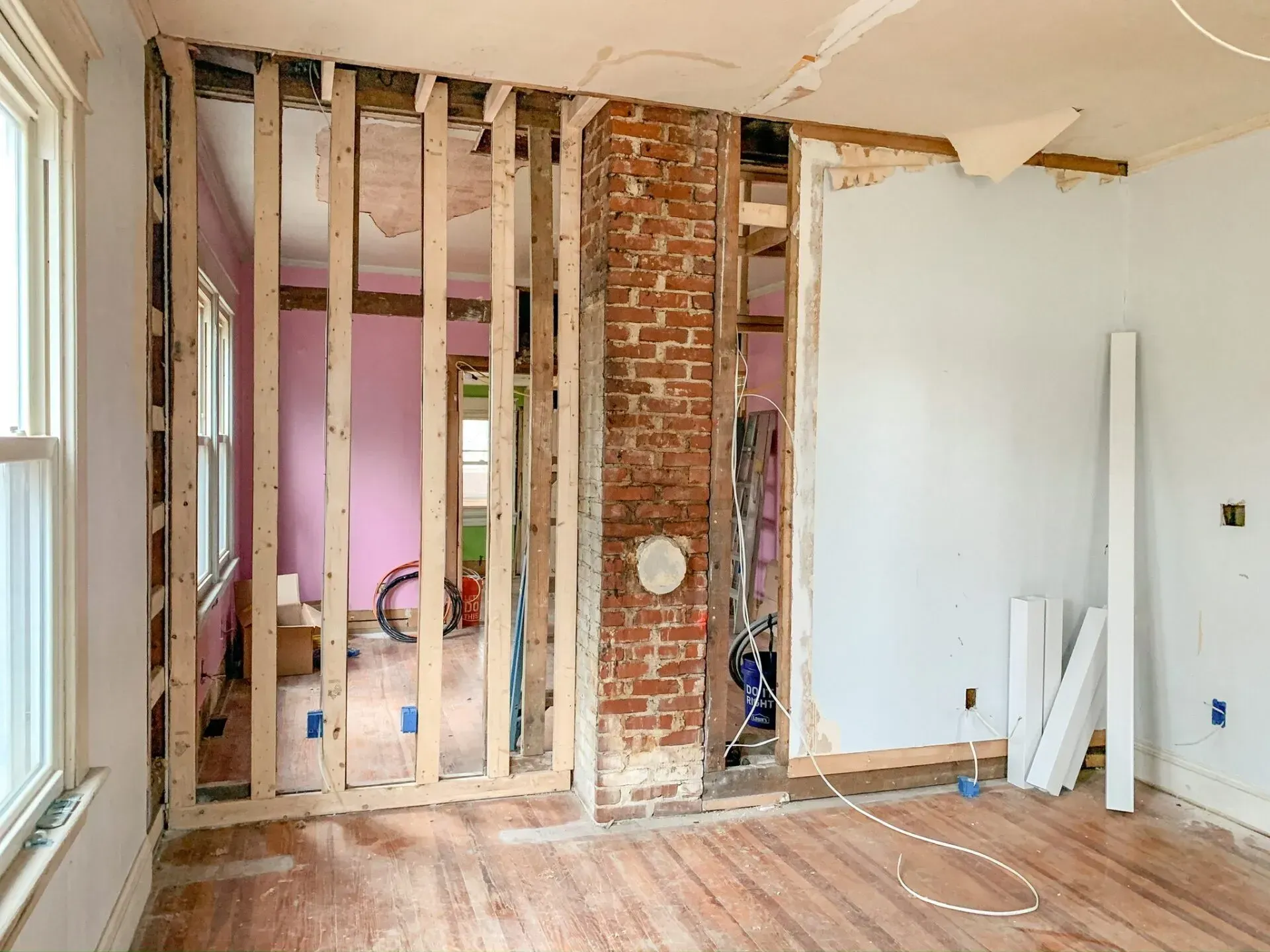A room under construction with a brick wall and wooden beams.