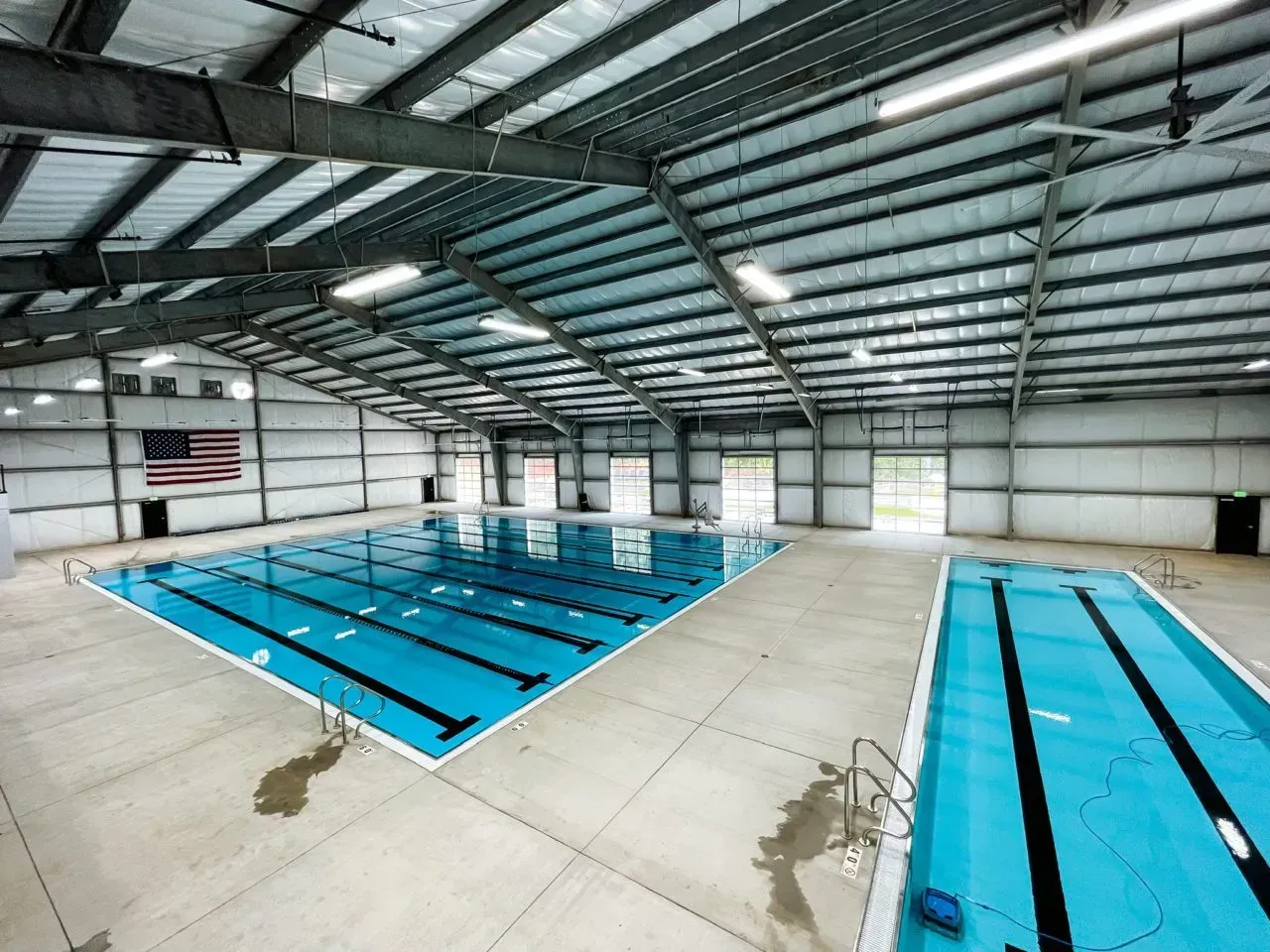 A large indoor swimming pool with an american flag in the background