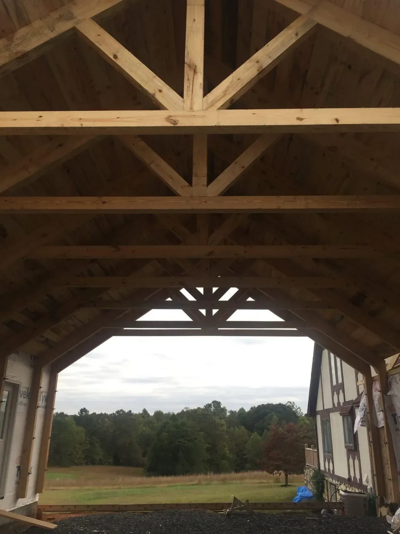 The inside of a wooden structure with a view of a field.