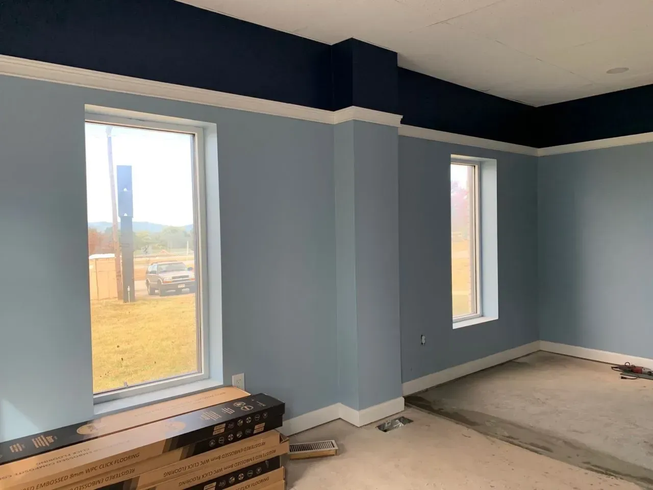 A room with blue walls and two windows.