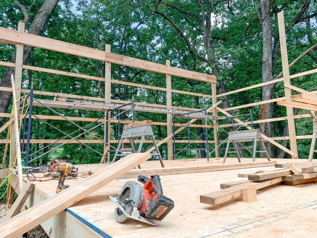 A circular saw is sitting on top of a wooden deck under construction.