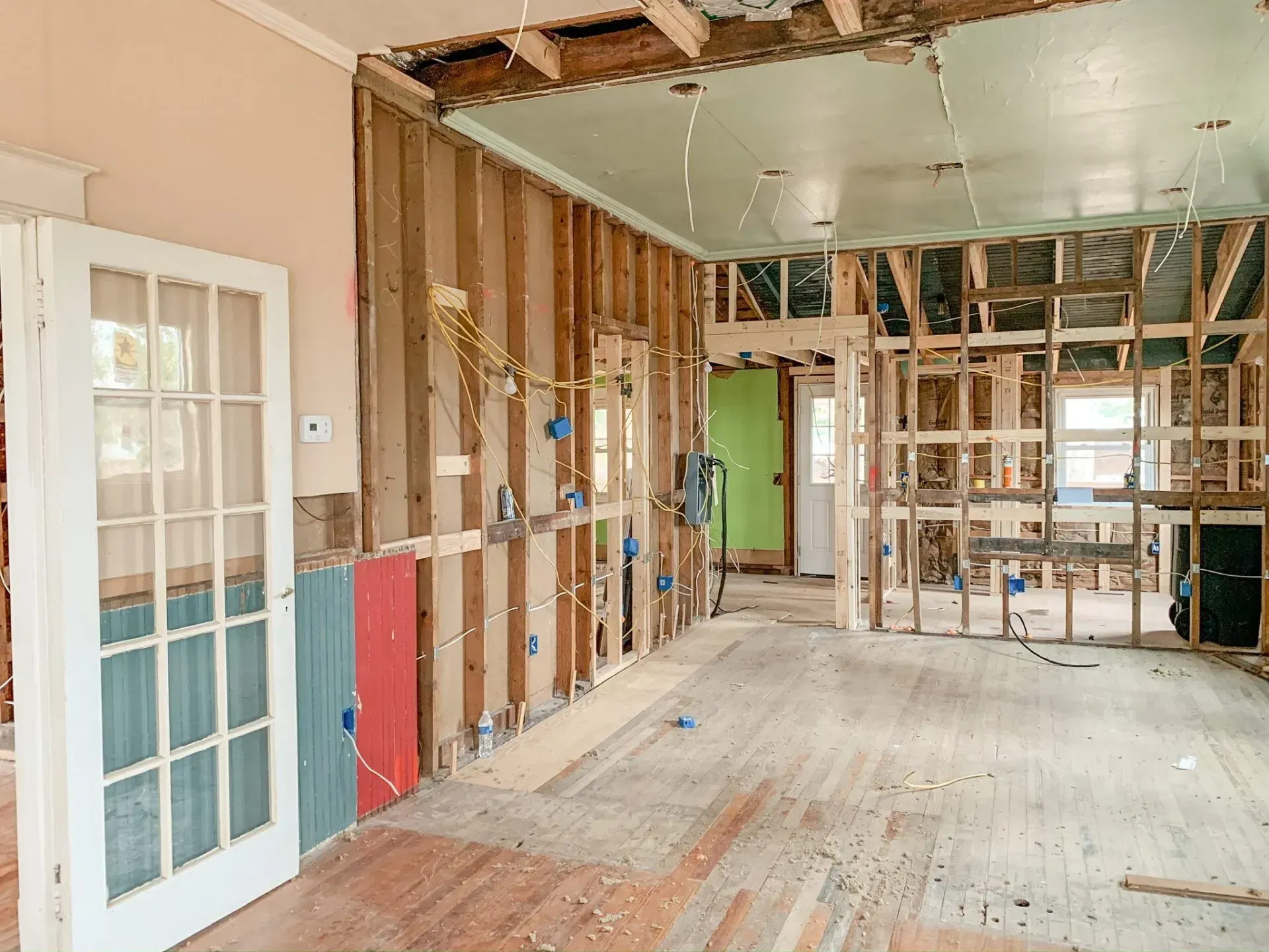 An empty room in a house under construction with a french door.