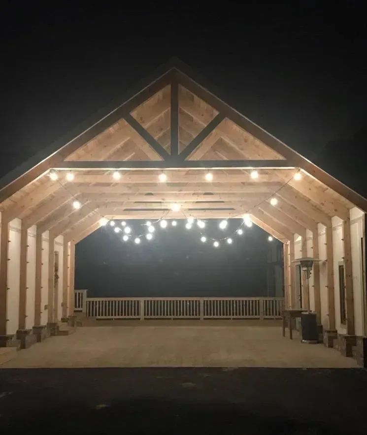 A large wooden building with lights hanging from the ceiling at night.