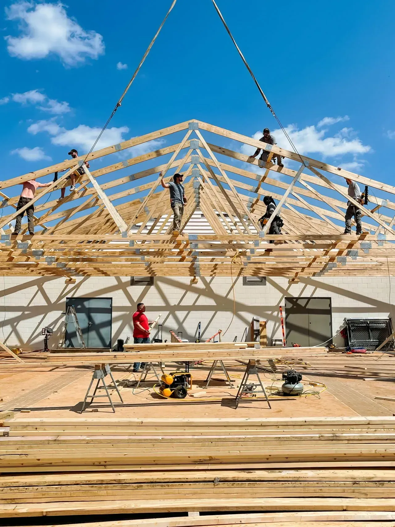A group of people are working on a large wooden structure.