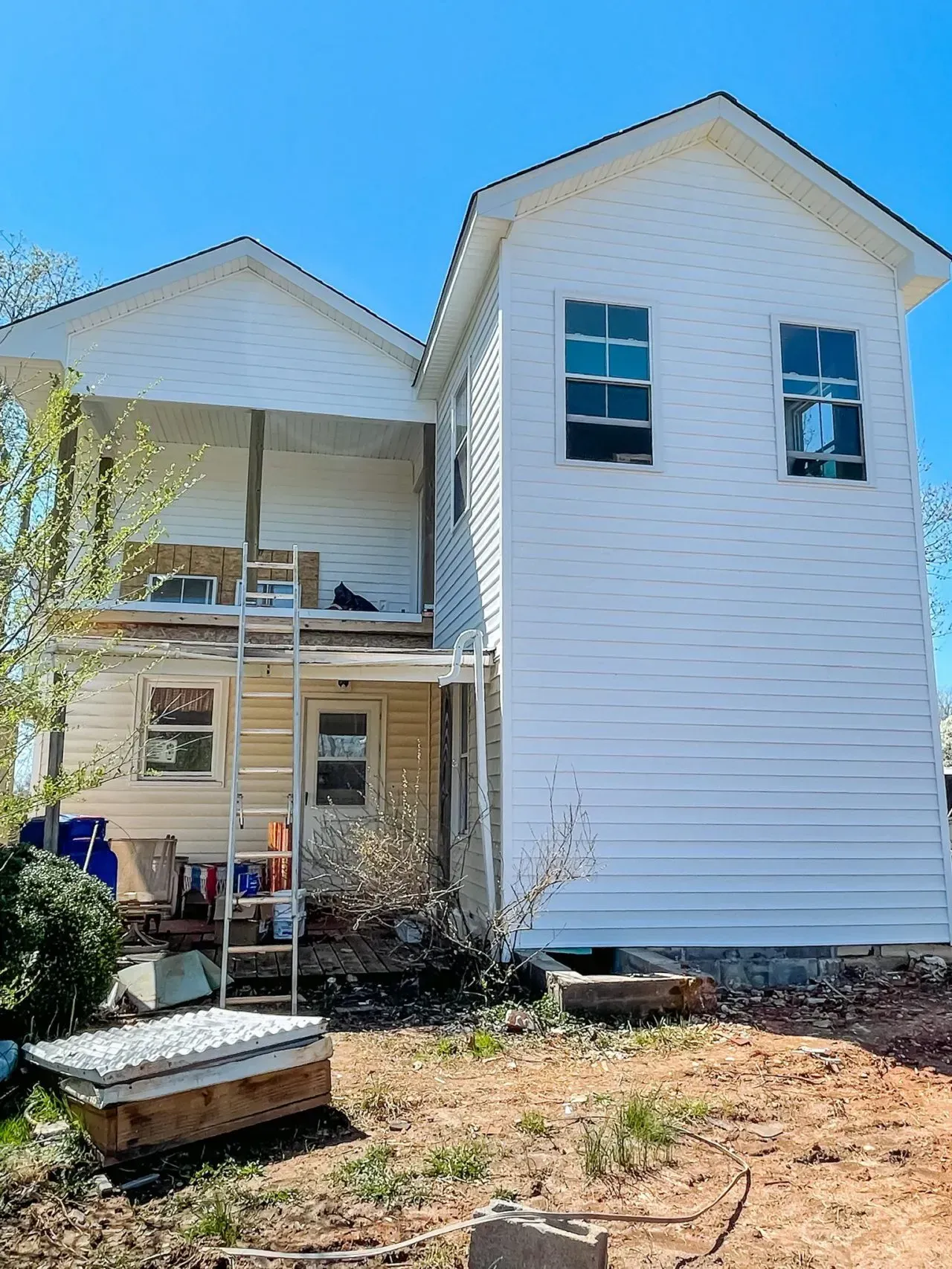 A white house with a ladder in front of it.