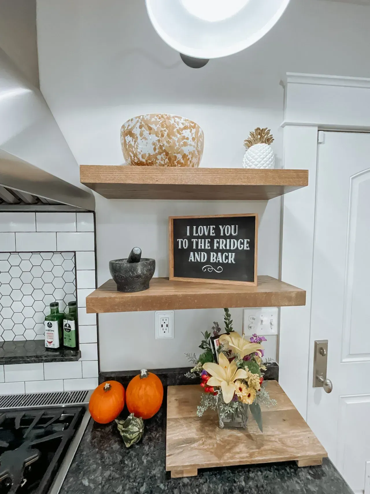 A kitchen with three shelves and a sign that says `` i love you to the bridge and back ''.