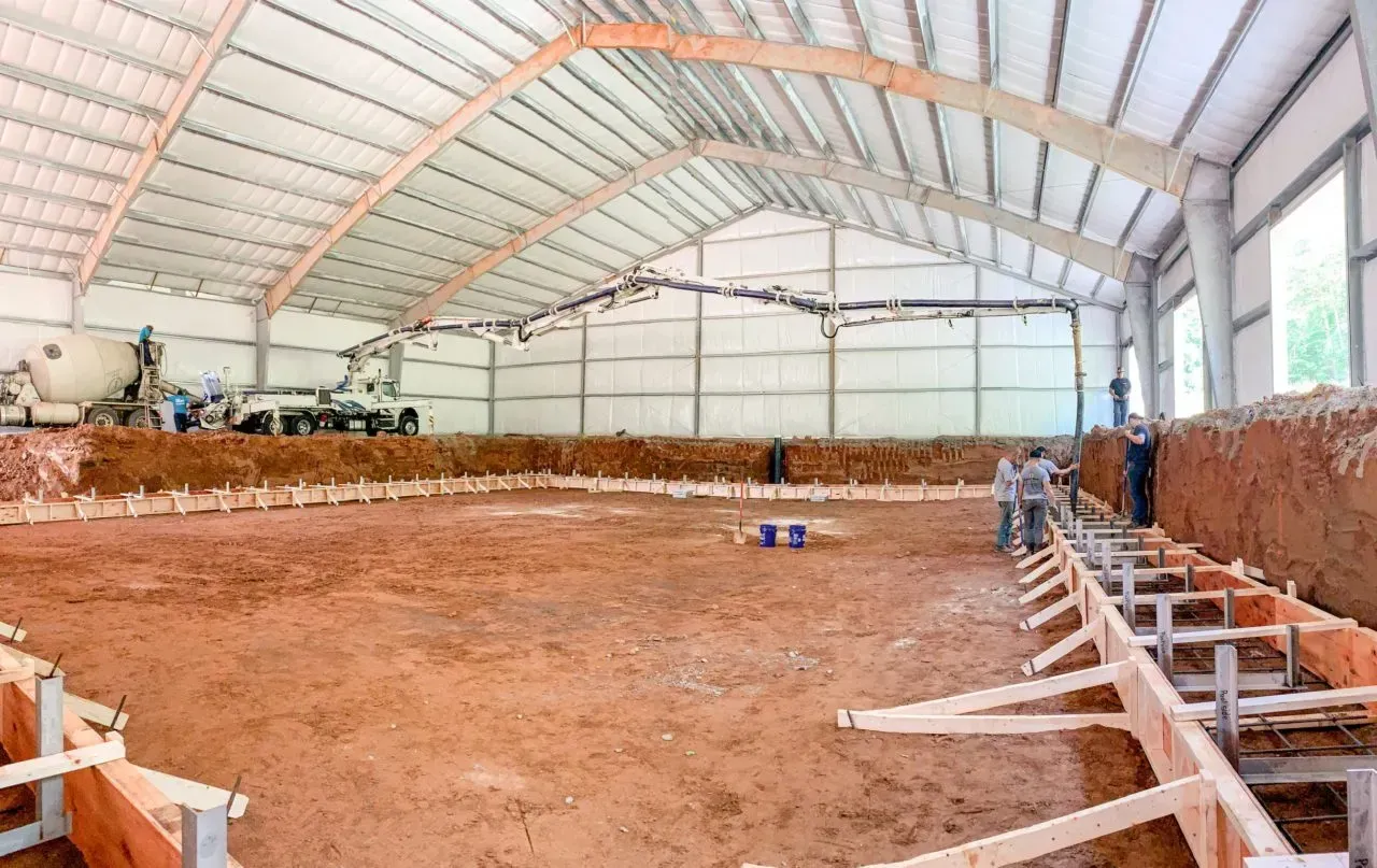 A large building under construction with a lot of dirt in it.
