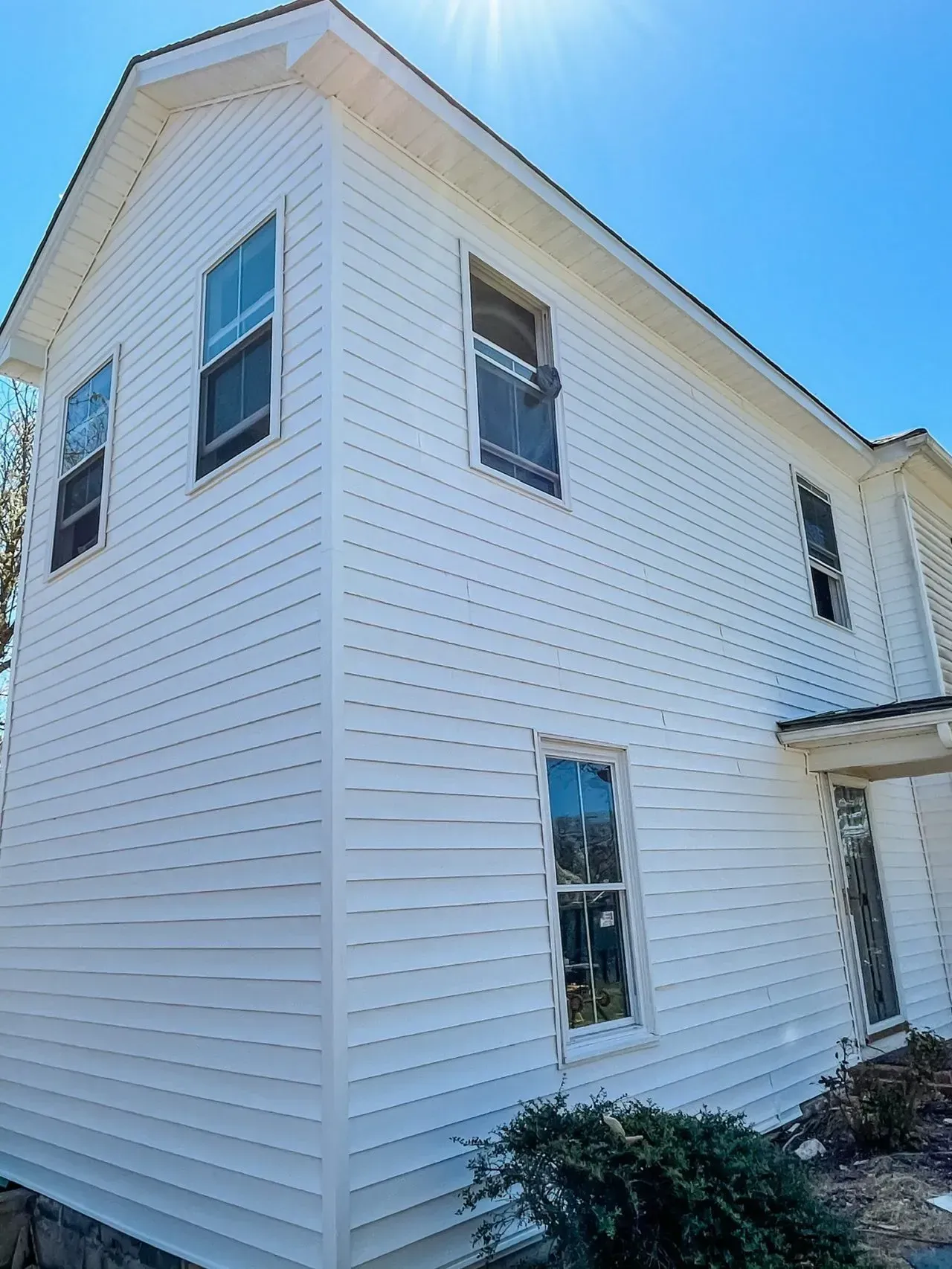 A large white house with a lot of windows on a sunny day.