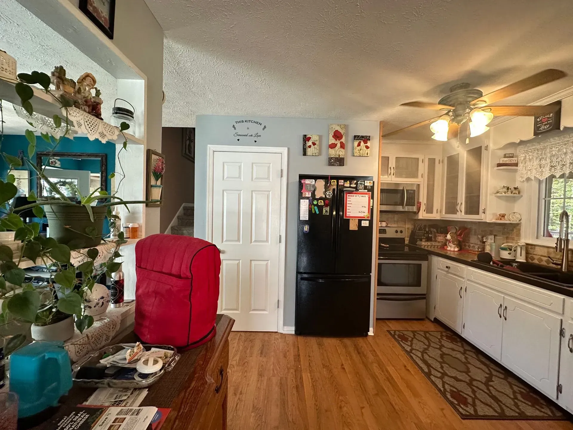 A kitchen with a black refrigerator and white cabinets.