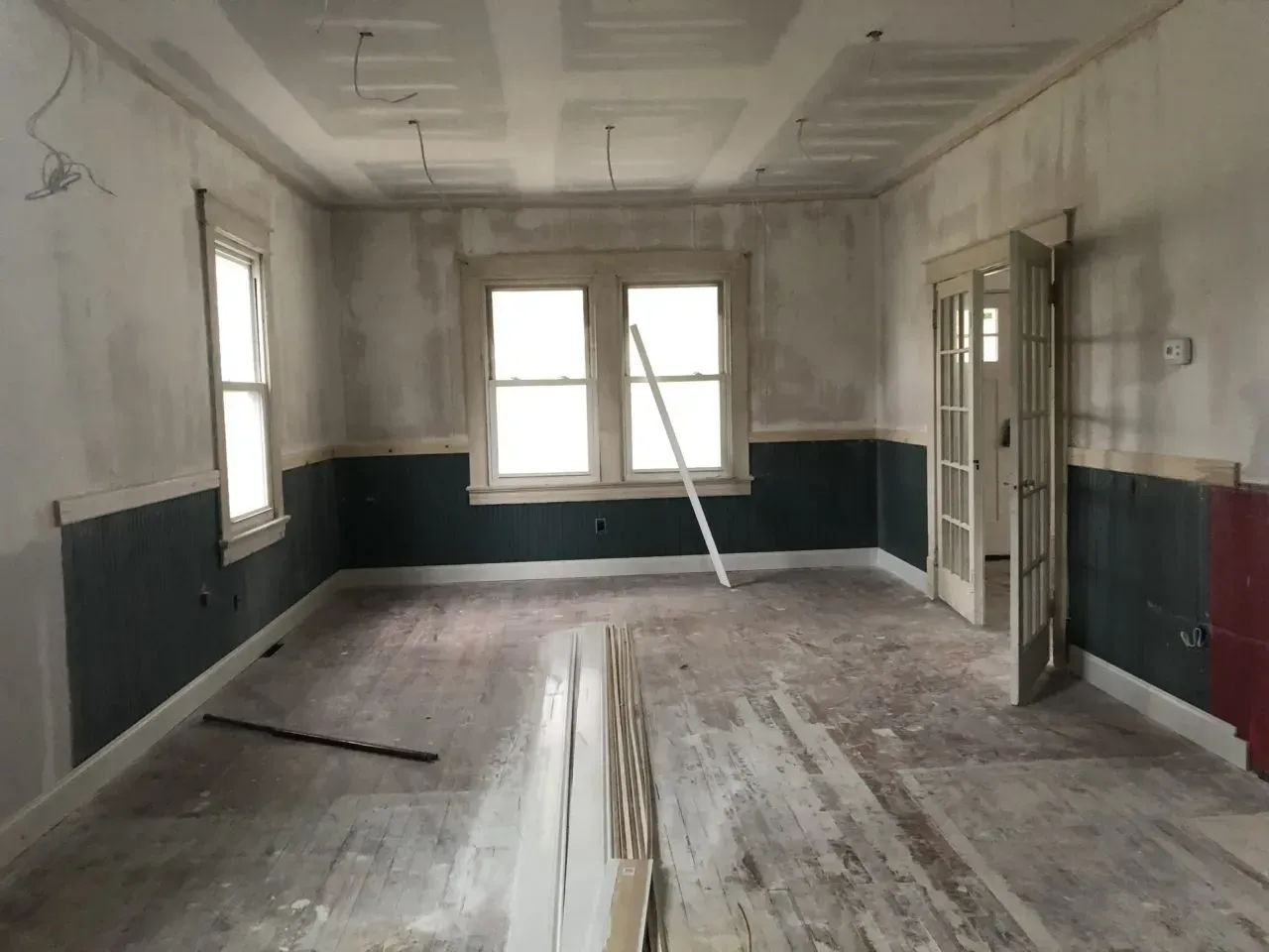 An empty room with a ladder hanging from the ceiling