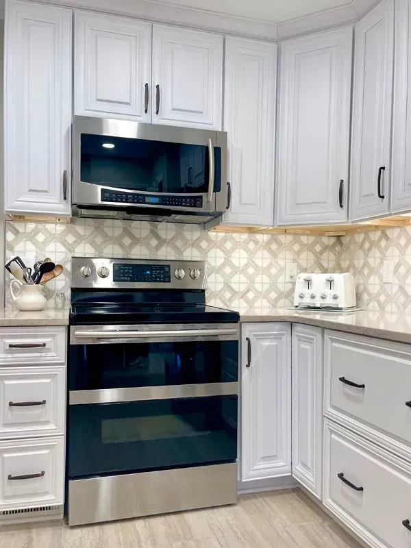A kitchen with stainless steel appliances and white cabinets