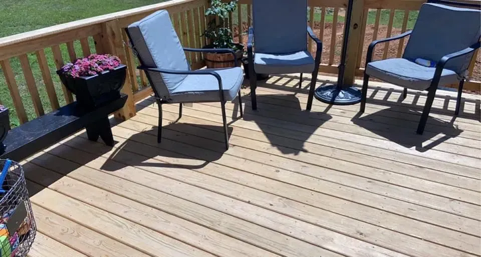 A wooden deck with chairs and a table on it.