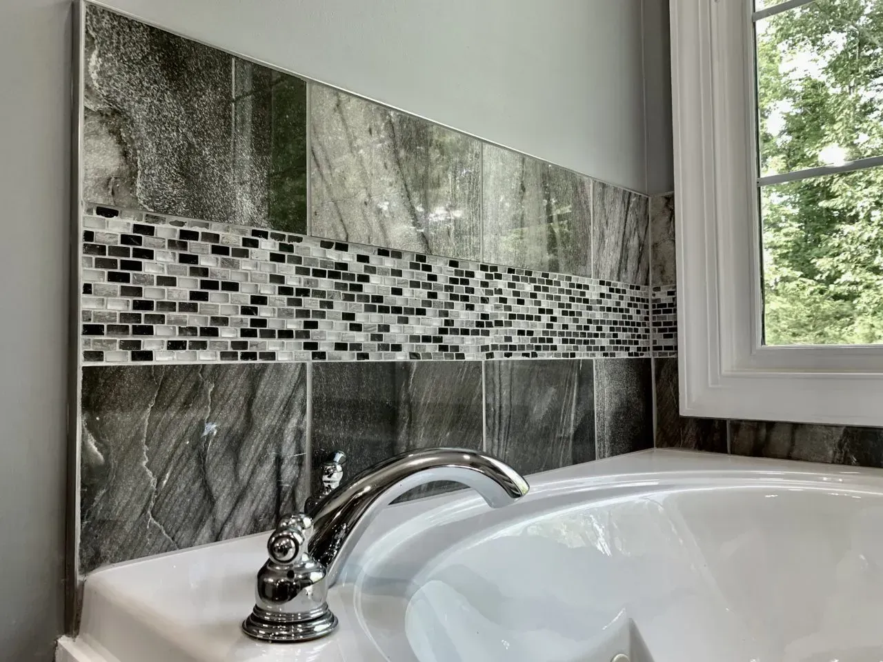 A bathroom sink with a faucet and a window.