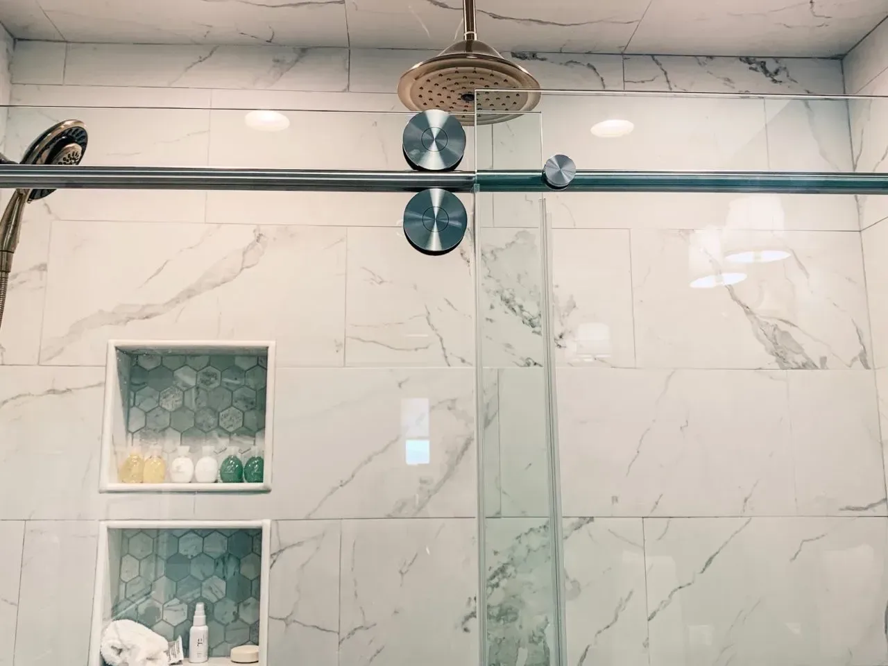 A shower with a sliding glass door and a shower head.