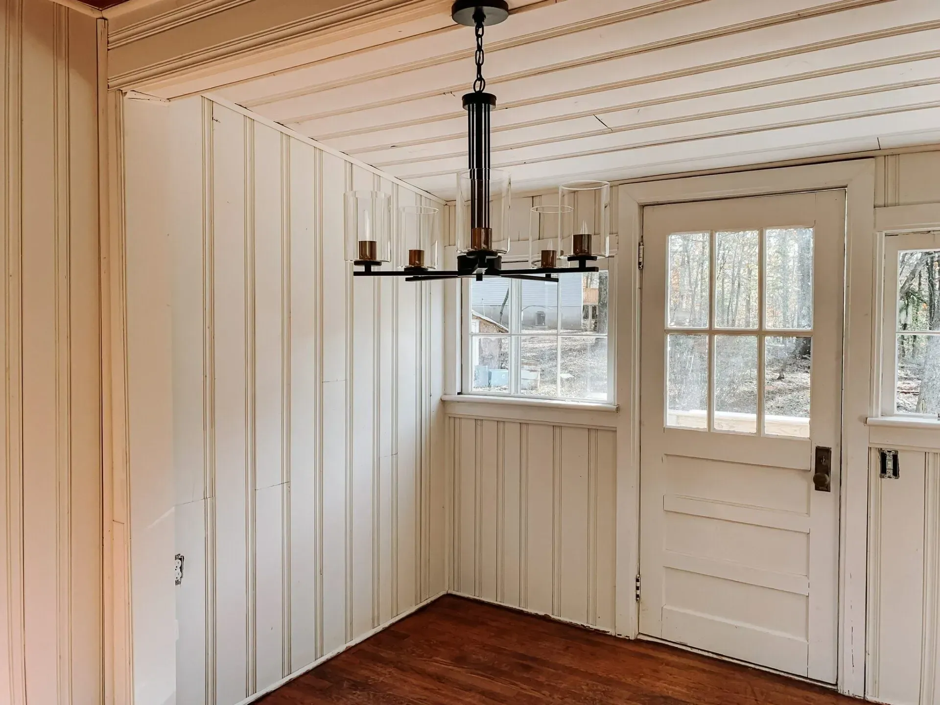 There is a chandelier hanging from the ceiling in the corner of the room.