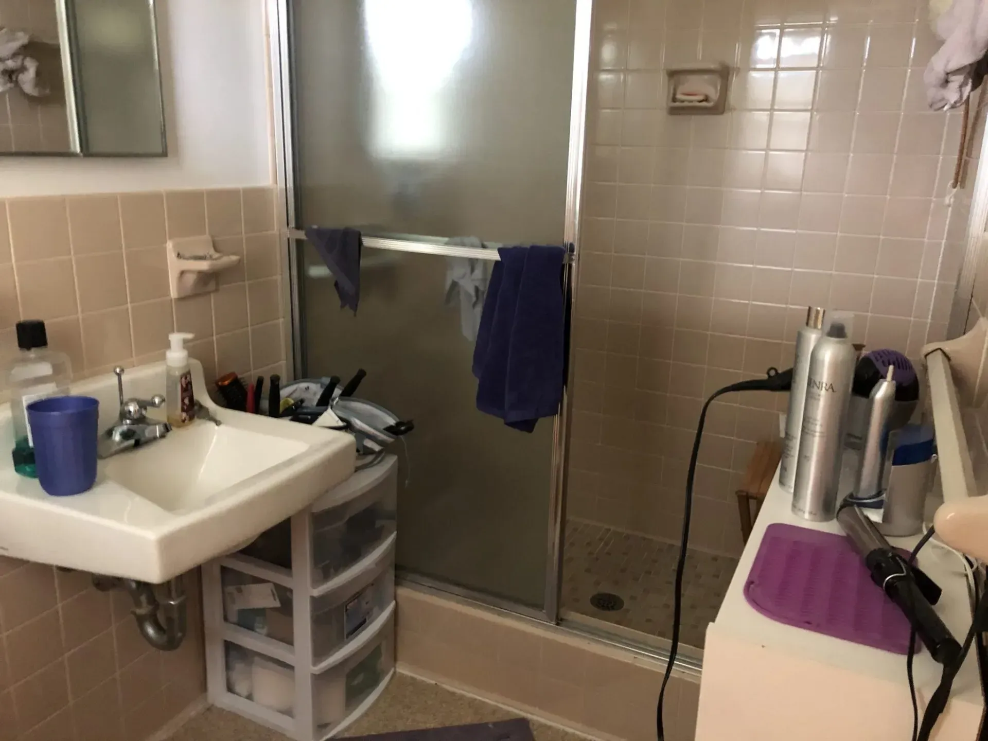 A bathroom with a sink , shower , and hair dryer
