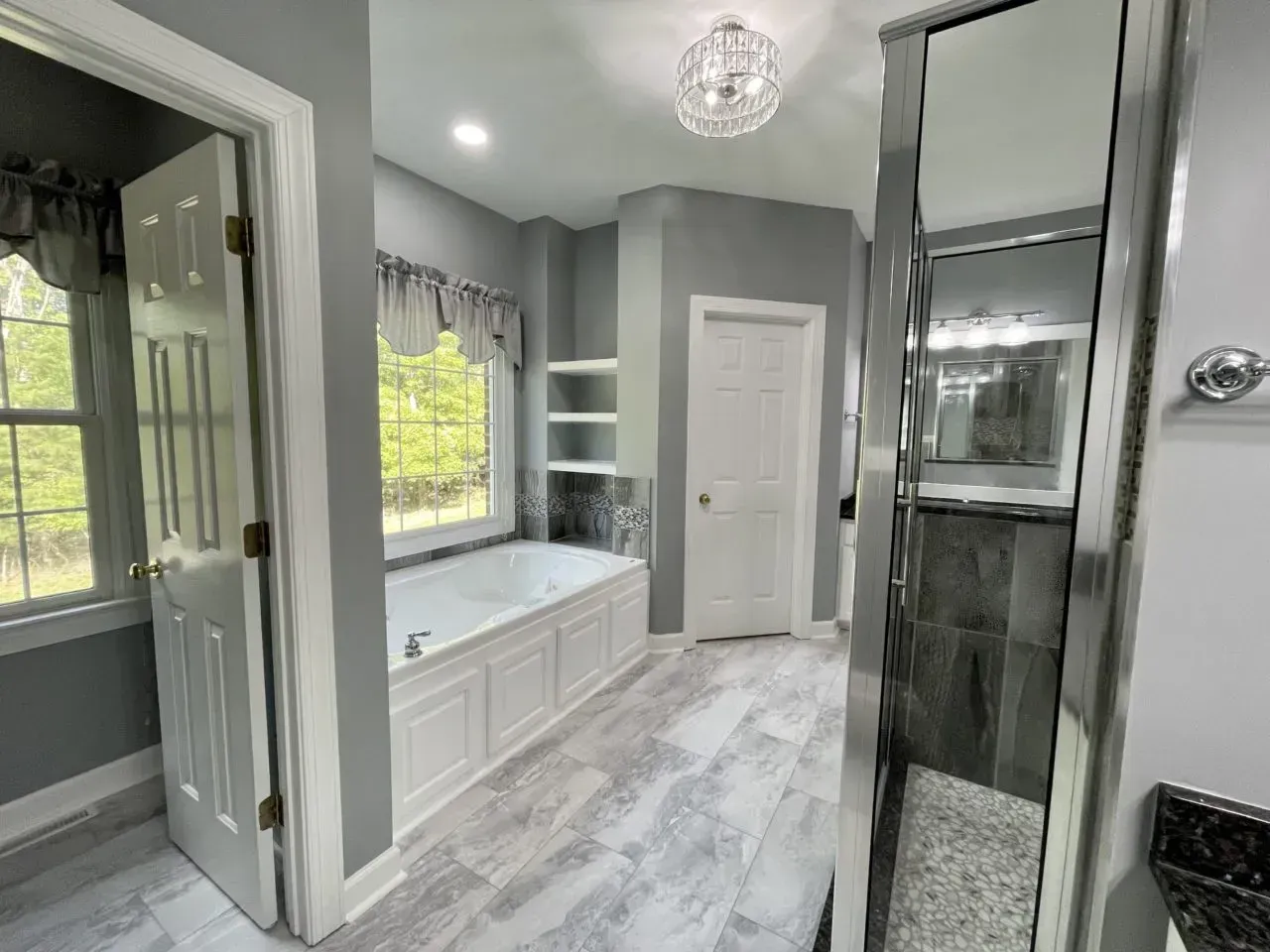 A bathroom with a tub , shower , sink and mirror.