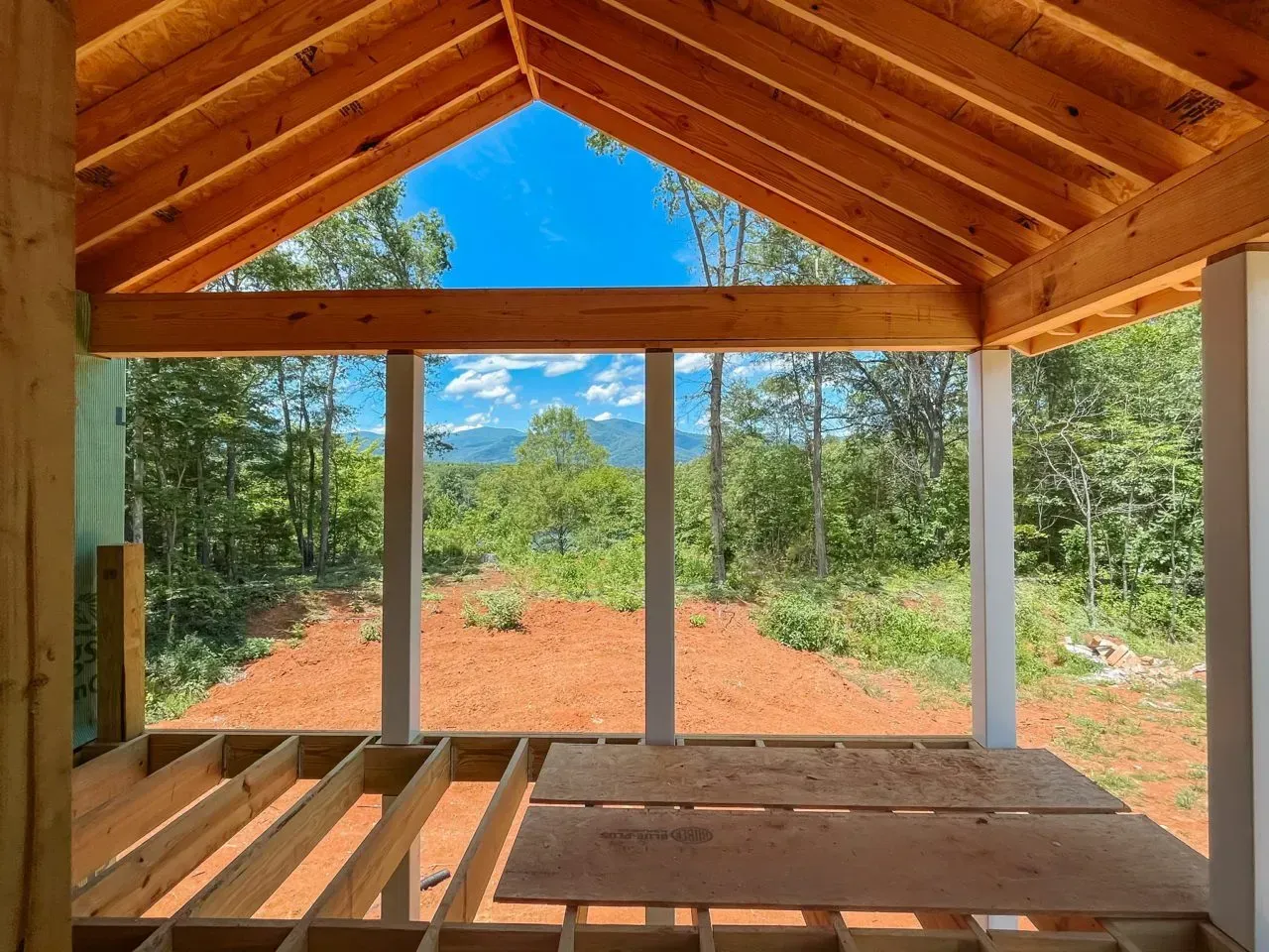 A room with a wooden ceiling and a view of a forest.