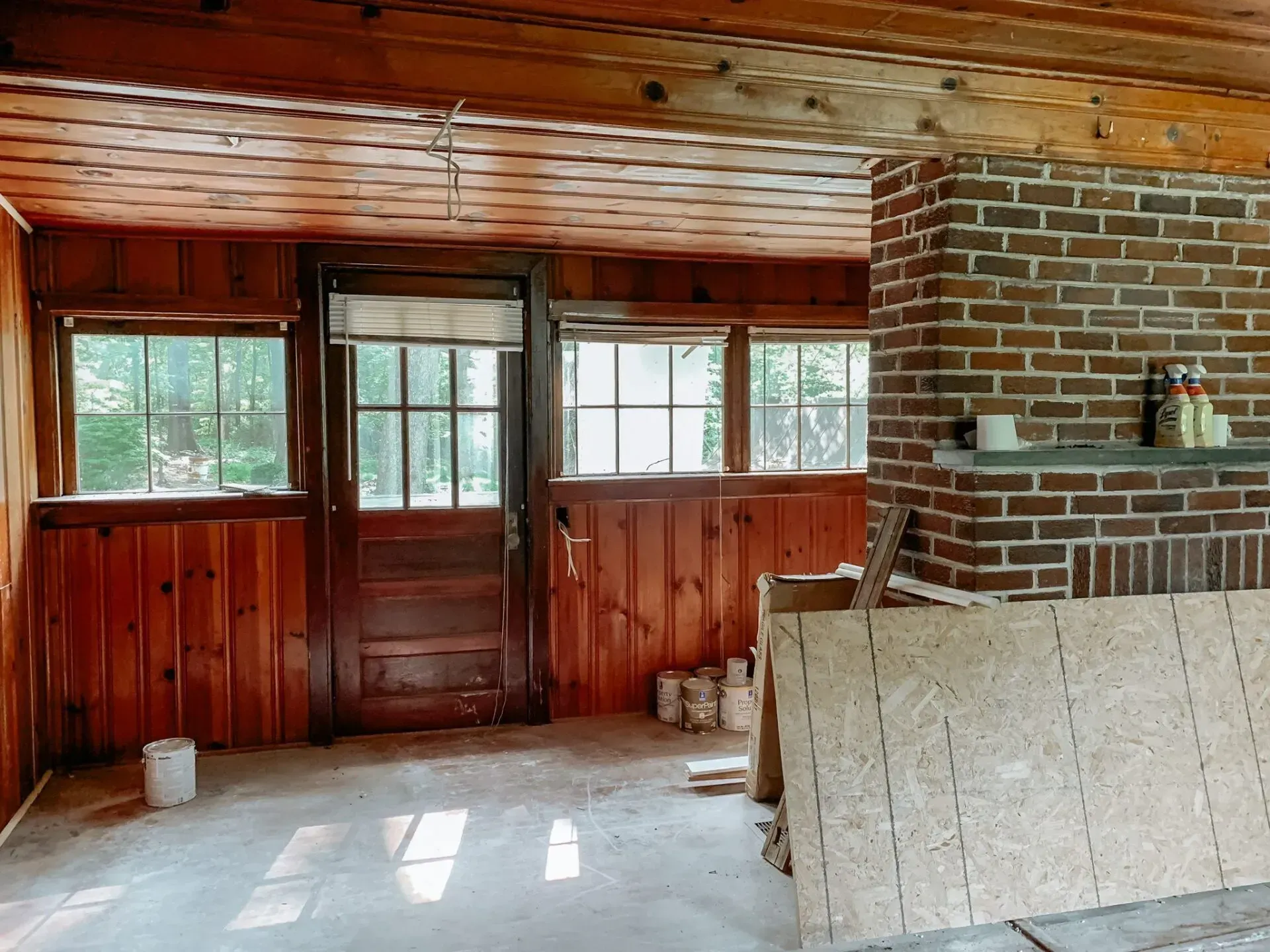There is a brick fireplace in the middle of the room.