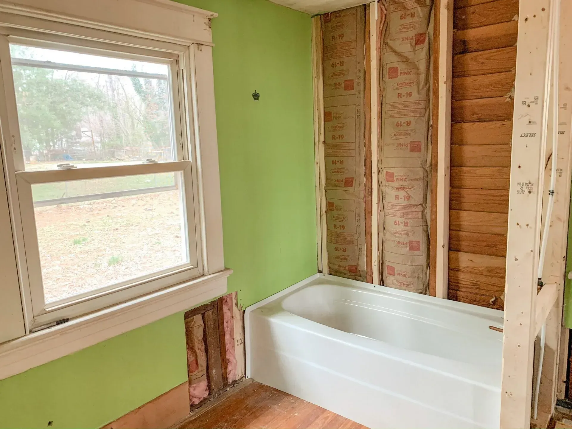 A bathroom with a bathtub and a window.