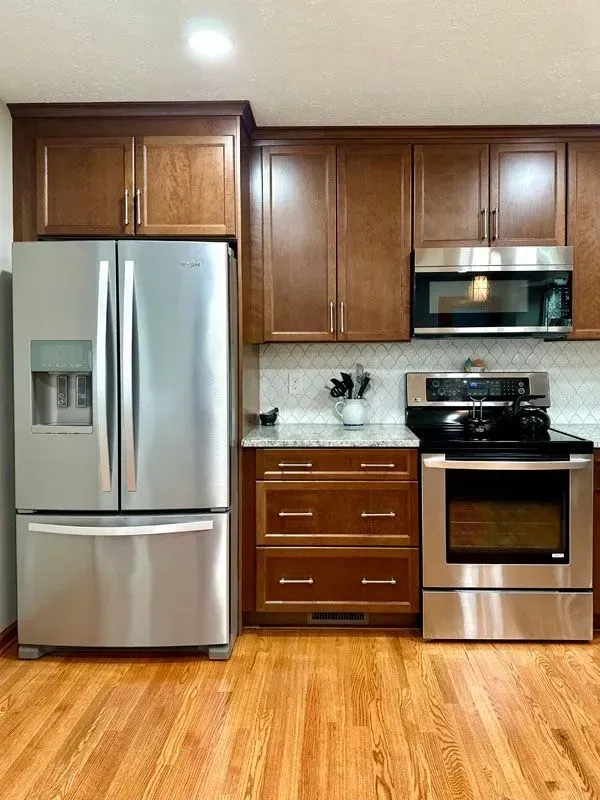 A kitchen with stainless steel appliances and wooden cabinets.
