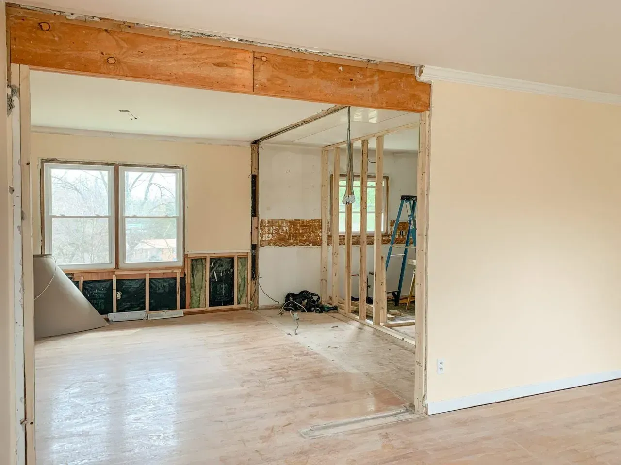 An empty room with a wooden beam between two walls.