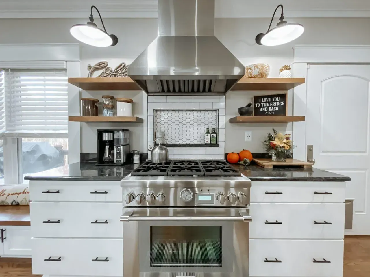 A kitchen with stainless steel appliances and white cabinets.