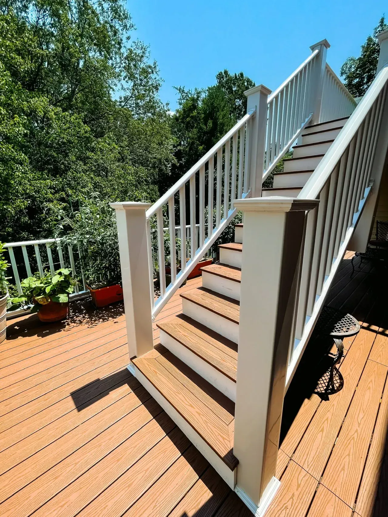 A wooden deck with stairs and a white railing