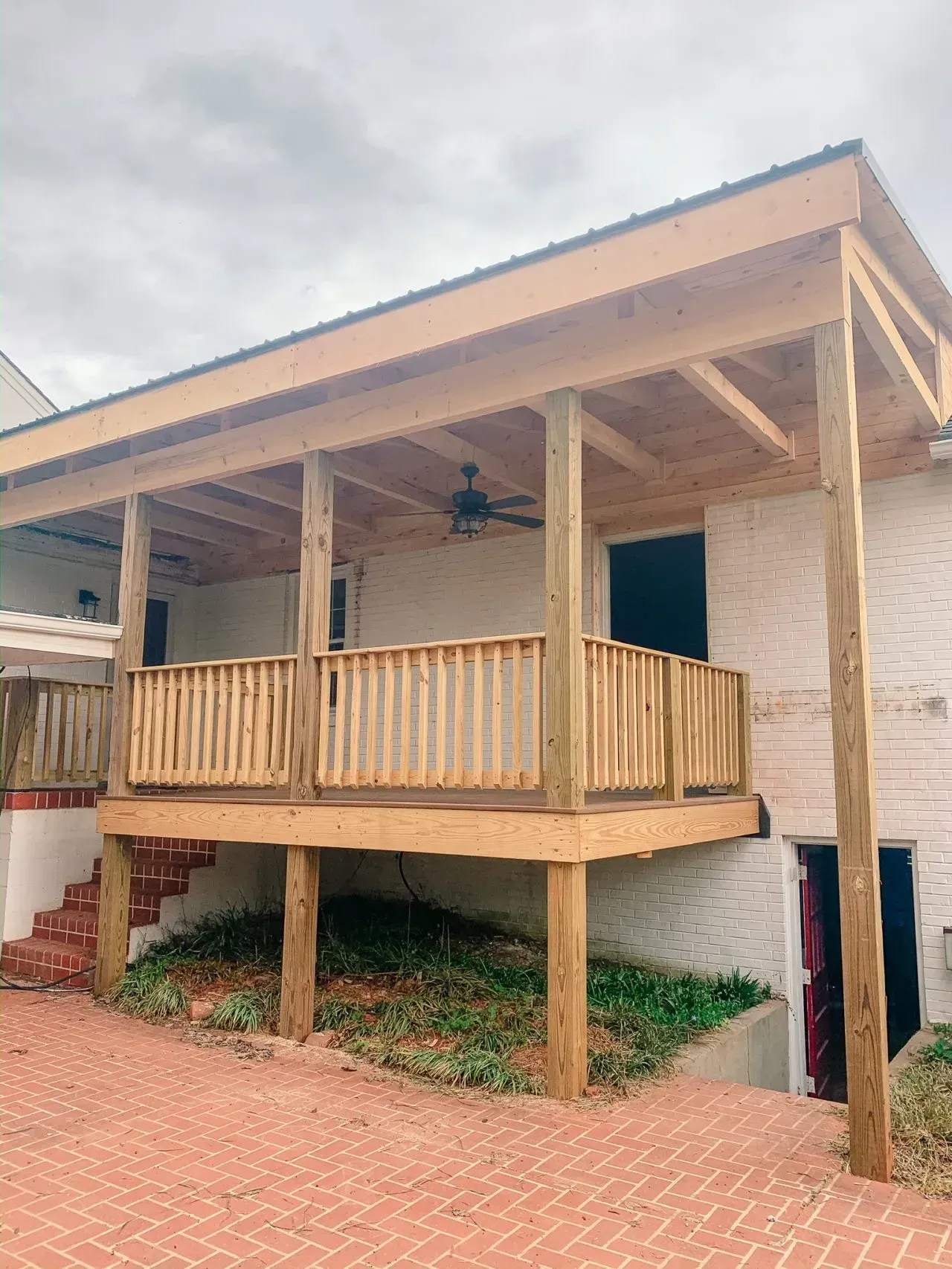 A house with a wooden deck and a ceiling fan.