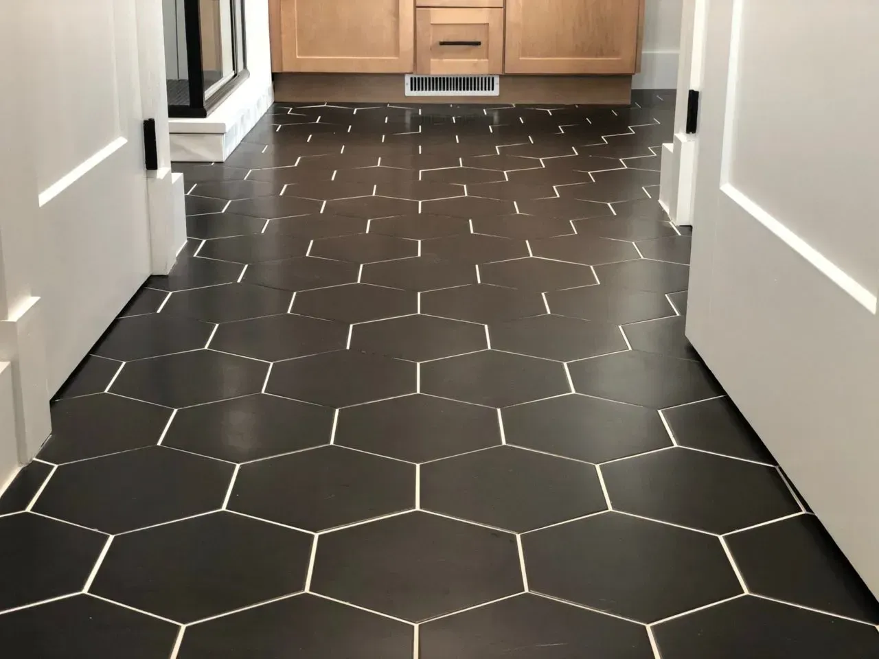 A hallway with a black tile floor and white lines