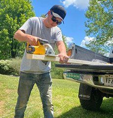 A man is using a circular saw to cut a piece of wood.