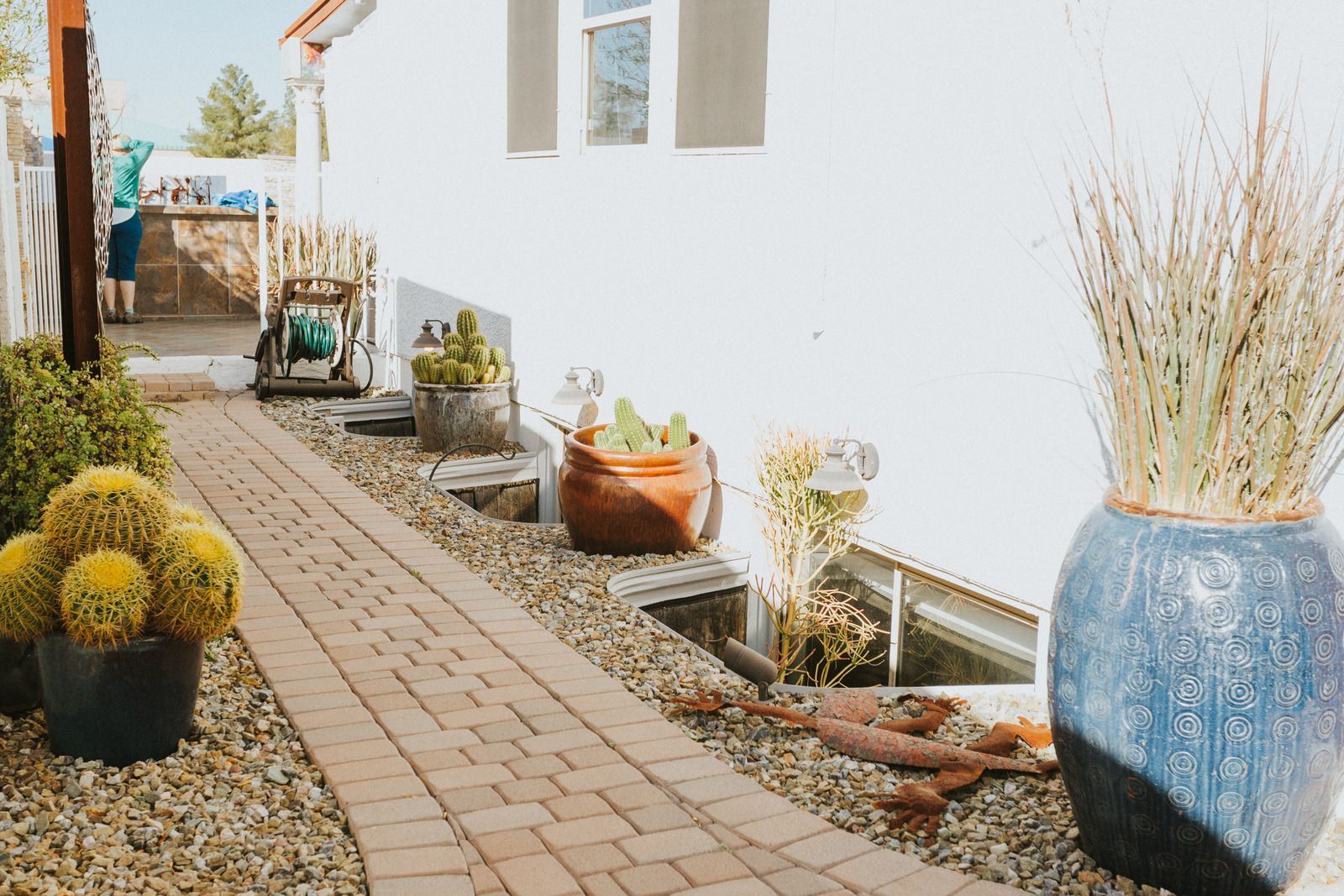A stone wall surrounds a set of stairs leading up to a house.