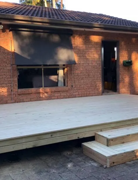 Newly Built Wooden Deck With Steps, Next to a Brick Building — Alcando Renovations and Maintenance In Harrington, NSW