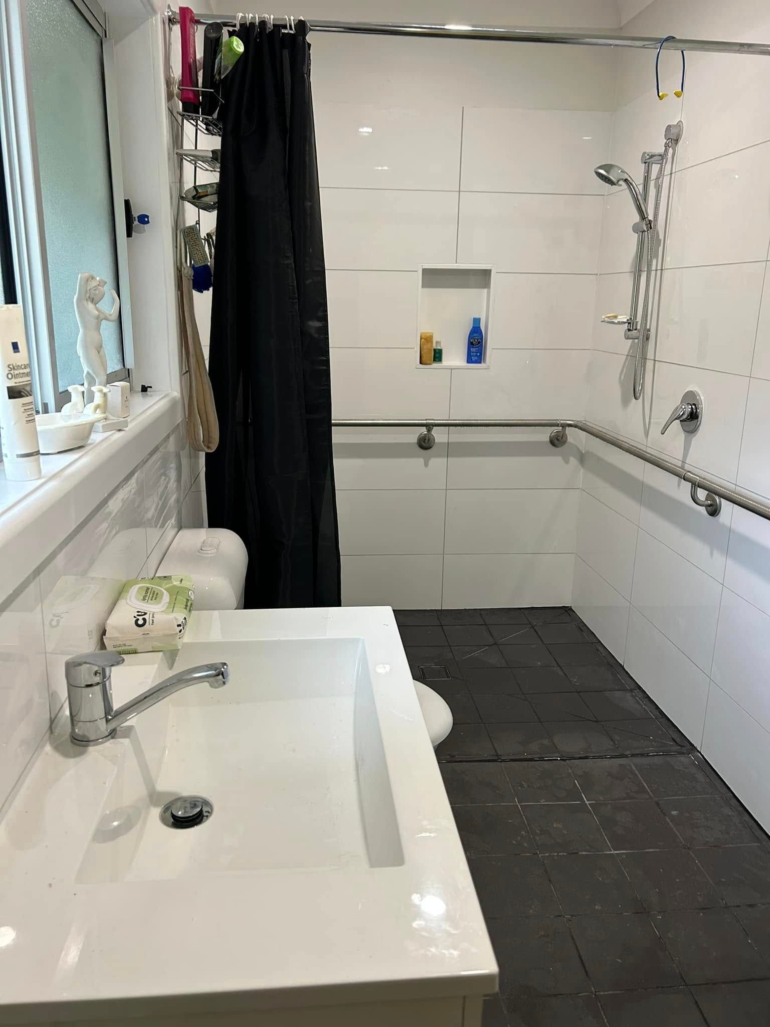 Bathroom With White Tile Walls, a Sink, and Shower With Handrails — Alcando Renovations and Maintenance In Forster, NSW