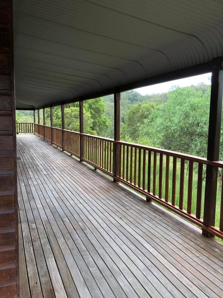 Wooden Porch With Railing and Roof Overlooking a Lush Green Landscape — Alcando Renovations and Maintenance In Wingham, NSW