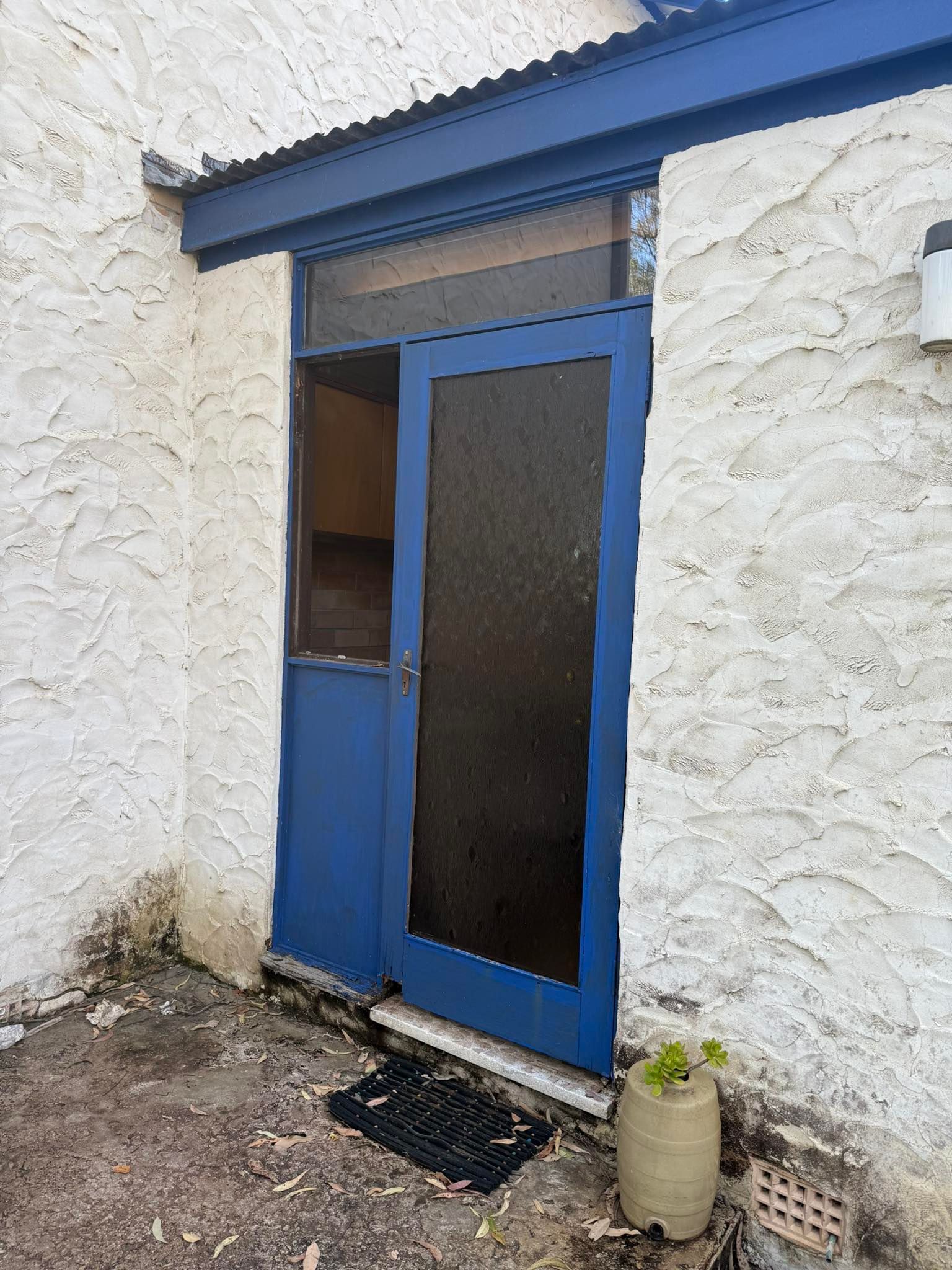 Blue Door, Screen Door, on White Stucco Building — Alcando Renovations and Maintenance In Harrington, NSW