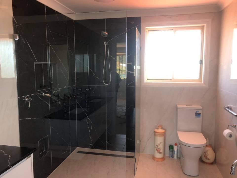 Bathroom With Black Tiled Shower, Toilet, and Window — Alcando Renovations and Maintenance In Taree, NSW