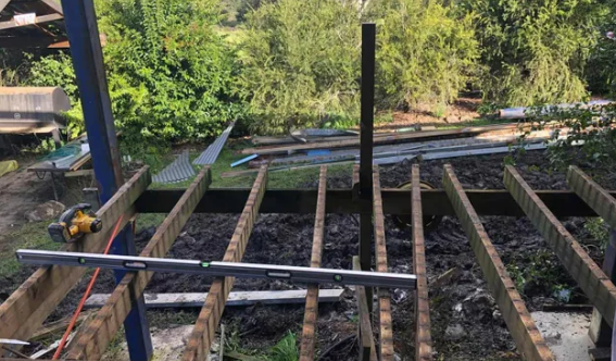 Deck Frame With Leveled Boards, Tools, and Lumber in an Outdoor Setting — Alcando Renovations and Maintenance In Wingham, NSW