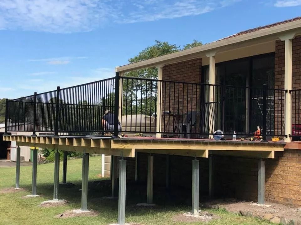 Elevated Wooden Deck With Black Metal Railing — Alcando Renovations and Maintenance In Harrington, NSW