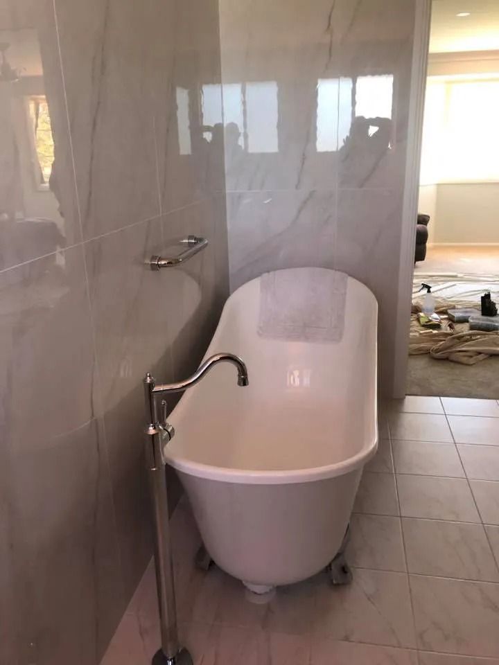 White Claw-foot Bathtub in a Tiled Bathroom With Chrome Fixtures — Alcando Renovations and Maintenance In Bobin, NSW