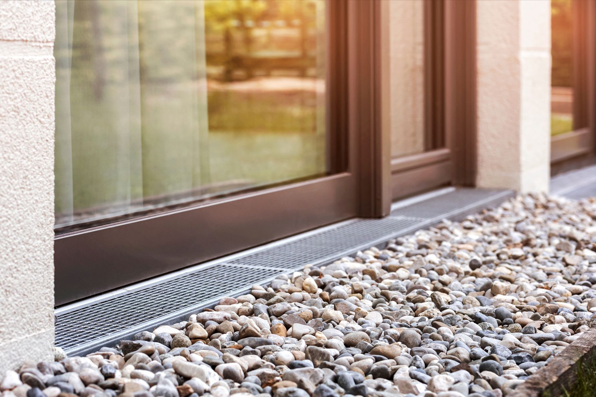 A close up of a window sill with gravel in front of it.