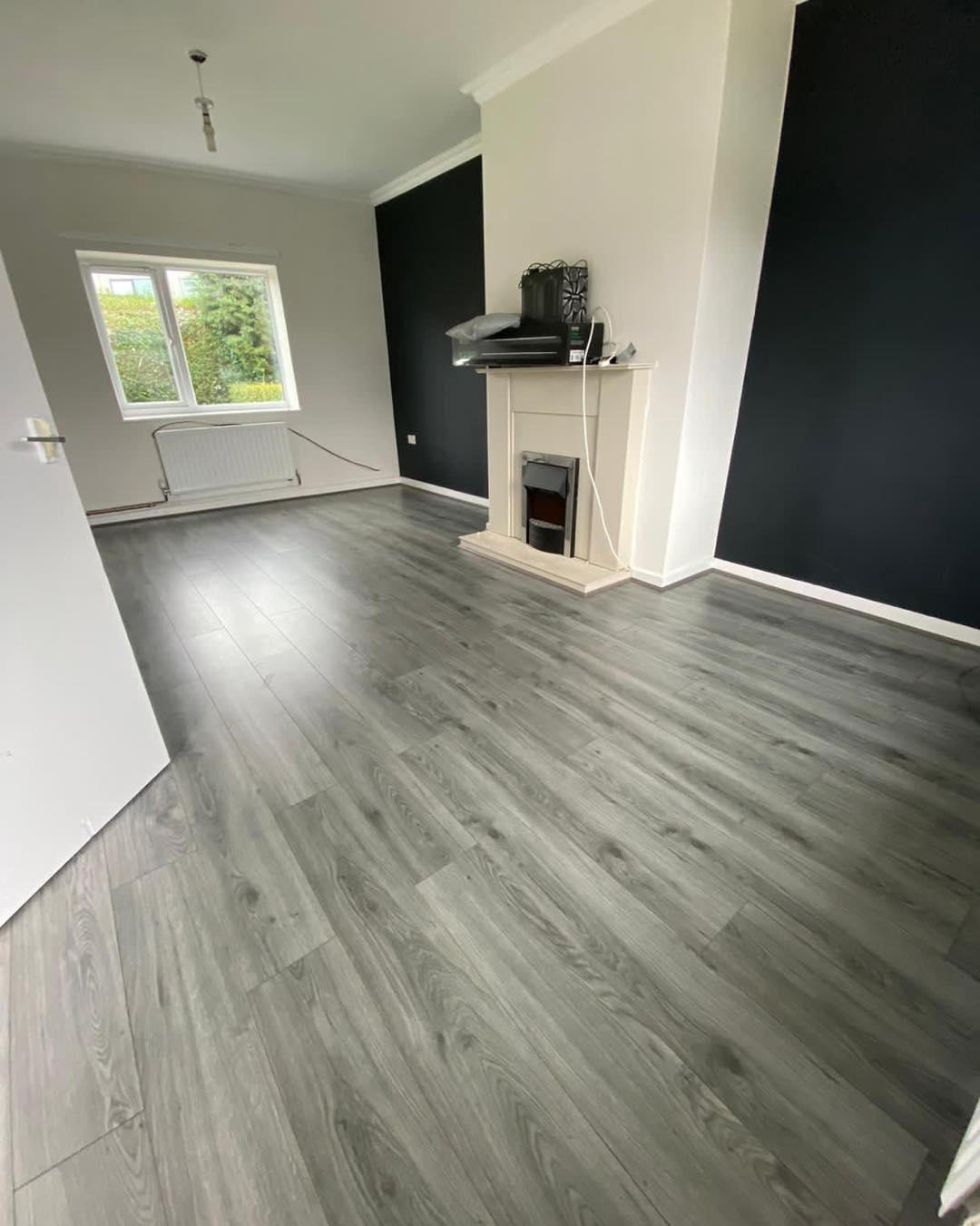 A living room with a fireplace and a wooden floor.