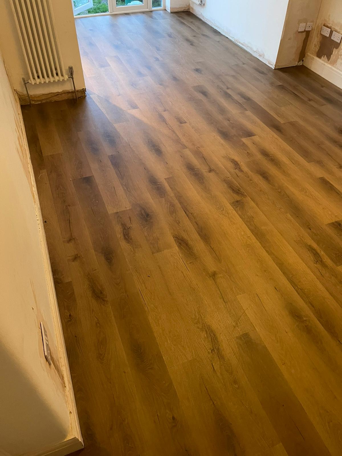 A living room with a wooden floor and a radiator.